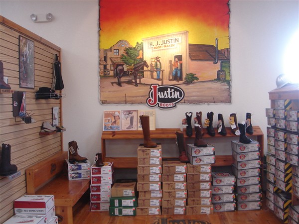 Justin Boots corner with boots displayed above stacked boot boxes