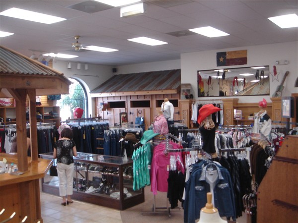 Women's clothing floor with racks of tops, jeans and hats
